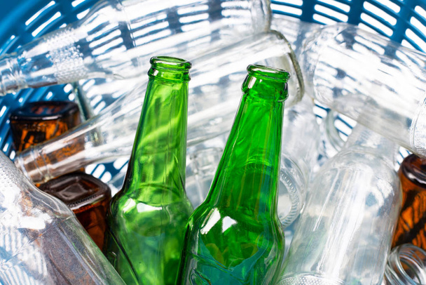 Glass bottles in blue waste basket. - Zdjęcie, obraz