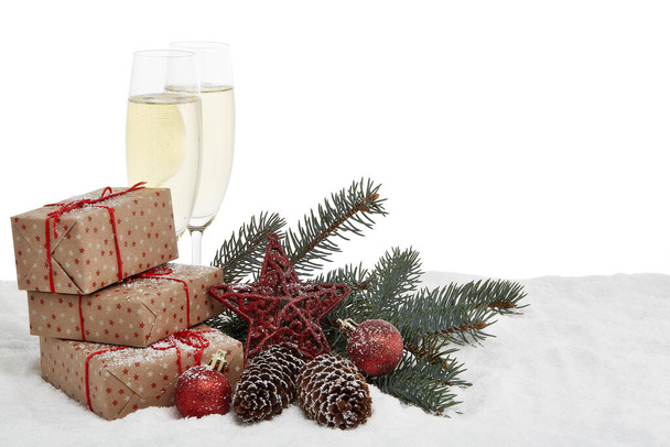 Still life with champagne bottle standing in a bucket with ice, two full champagne flutes, gift box and Christmas ornaments. Christmas and New Year  background with copy space.  Greeting card - 写真・画像