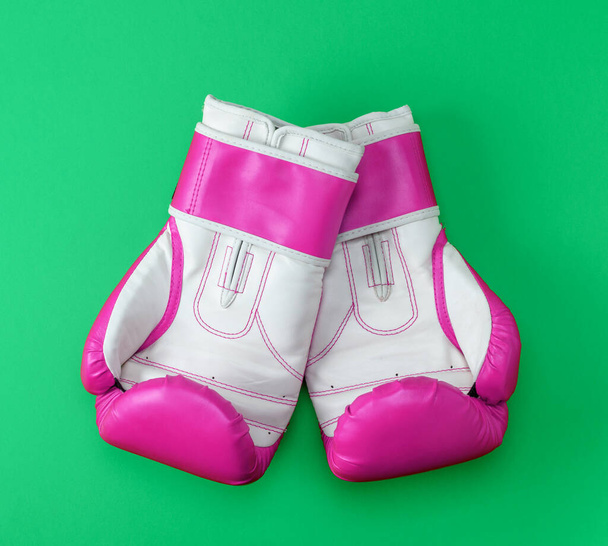 pair of pink-white leather boxing gloves on a green background, top view - 写真・画像