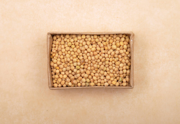 Mustard seeds in carton on brown background - Photo, image