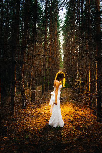 Bride with a tattoo on a background of leaves and forest backlight. - Photo, image