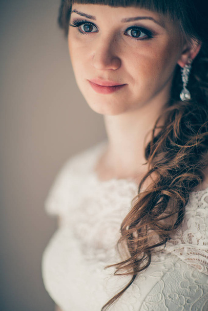 portrait of a young bride smiling and standing near a window. - Foto, imagen
