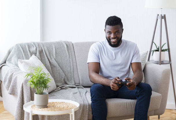 Adult african man playing video games at home - Fotó, kép