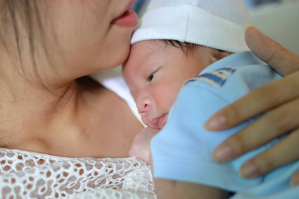 pequeño bebé recién nacido abrazando a la madre con amor
 - Foto, Imagen