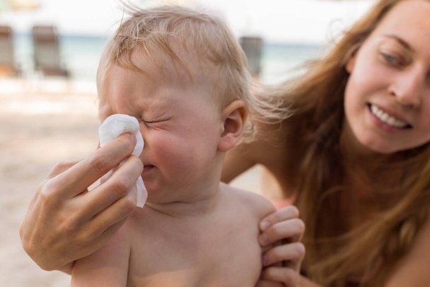 Moeder helpt baby neus te snuiten - Foto, afbeelding