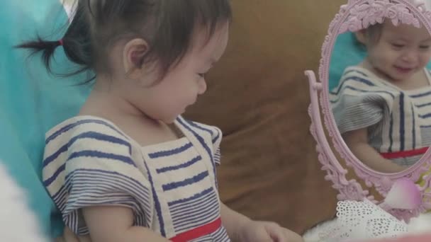 Jó idő az ázsiai családoknak A szülők ülnek és nézik a gyerekeket Sminkelő lányok anya kozmetikumaival boldogan. - Felvétel, videó