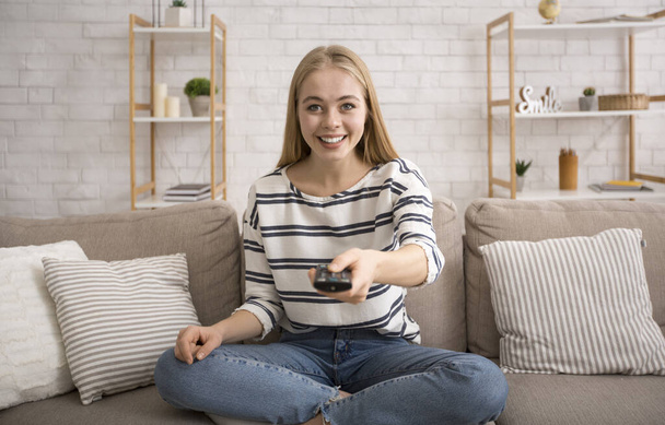 Mujer atractiva joven viendo la televisión en casa
 - Foto, imagen