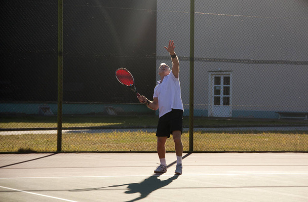 Ein älterer Mann über sechzig spielt Tennis. - Foto, Bild
