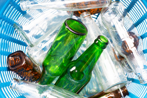 Glass bottles in blue waste basket. - Zdjęcie, obraz