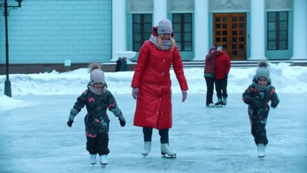 Una giovane donna bionda che pattina sul ghiaccio con i suoi figli
 - Filmati, video