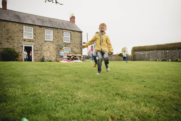 Children runnning as they search with excitement for chocolate easter eggs. - Foto, imagen