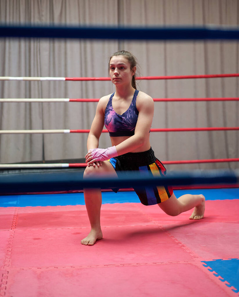 Kickbox fighter girl stretching before training - Foto, imagen