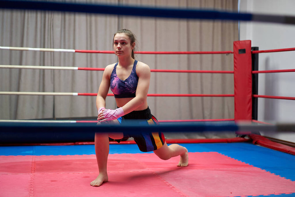 Kickbox fighter girl stretching before training - Foto, imagen