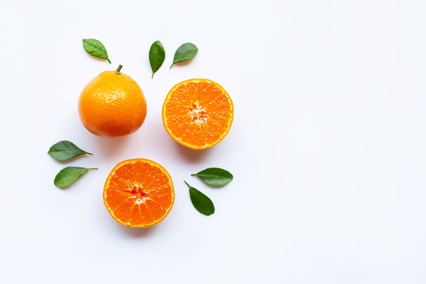 Orange fruits and green leaves on a white background. Copy space - Photo, image
