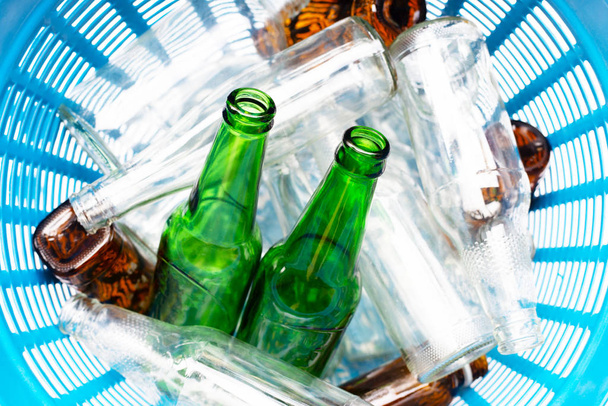 Glass bottles in blue waste basket. - Fotografie, Obrázek