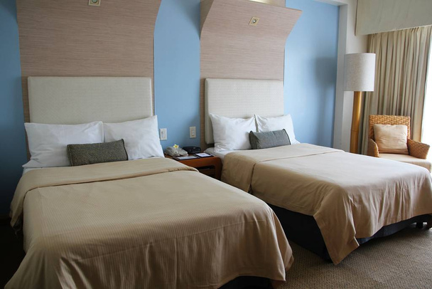 Eigentijdse hotelkamer met twee queensize bedden - Foto, afbeelding