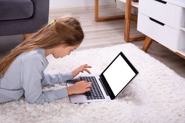 Side View Of A Girl Using Laptop With Blank White Screen - Фото, изображение