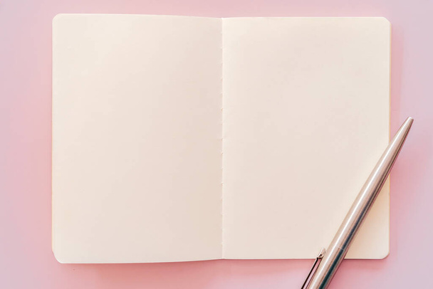 Σημειωματάριο και στυλό σε ροζ φόντο υφή. - Φωτογραφία, εικόνα