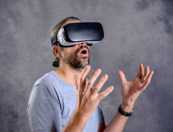 young man with virtual reality glasses looking surprised - Fotografie, Obrázek