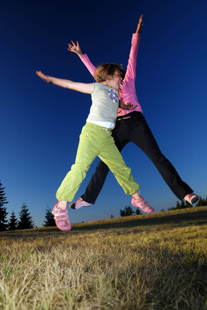 happy girls Jumping in to air - Φωτογραφία, εικόνα