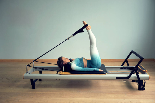 young asian woman pilates stretching sport in reformer bed instructor girl in a studio - Photo, Image
