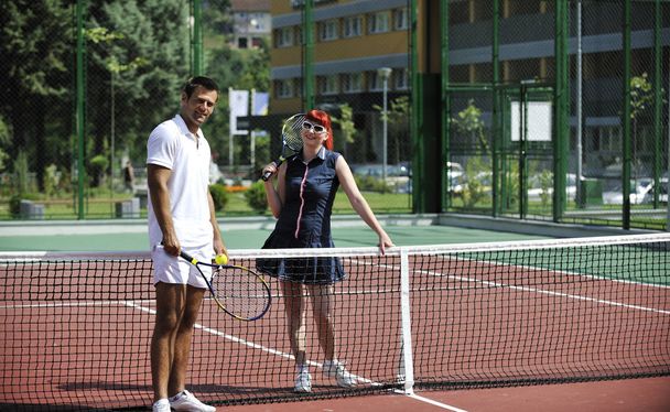 happy young couple play tennis game outdoor man and woman - Foto, Imagen