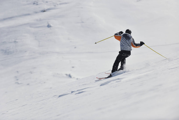 férfi síelés ingyenes lefelé a téli szezonban a gyönyörű napsütéses napon és hó por - Fotó, kép