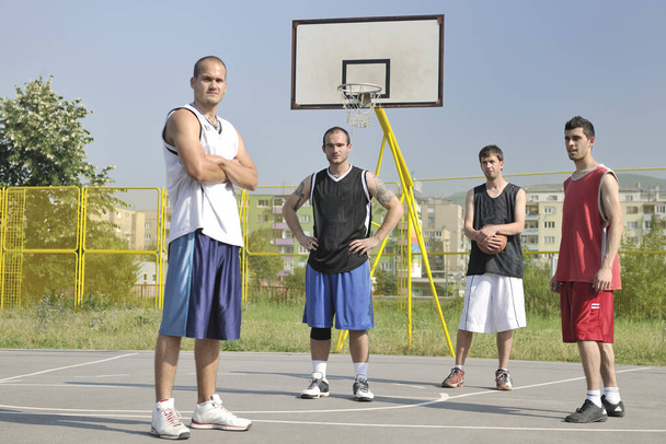grupo de jugadores de baloncesto posando en la cancha callejera de la ciudad temprano en la mañana
 - Foto, Imagen