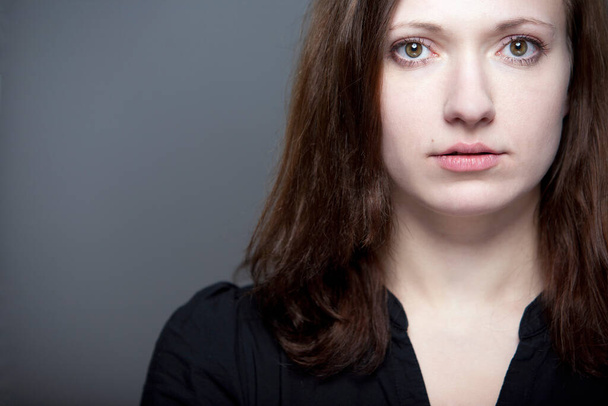 young drama student with intense look against gray background - 写真・画像