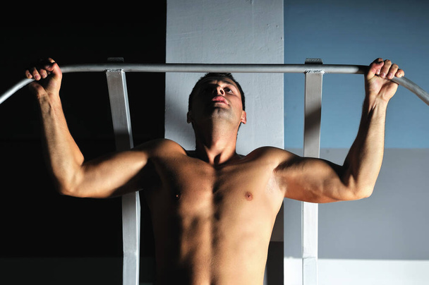 young man with strong arms working out in gym and representing their streinght and vitality - Photo, Image