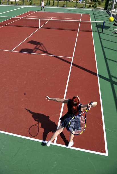 young fit woman play tennis outdoor on orange tennis field at early morning - Φωτογραφία, εικόνα