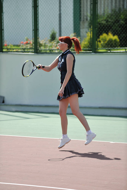 genç kadın oyun Tenis açık portakal Tenis alanında erken sabah saat yerleştirmek. - Fotoğraf, Görsel