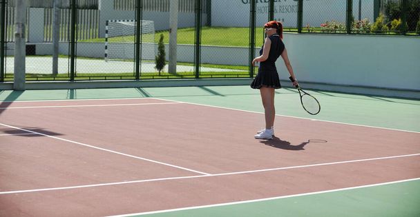 young fit woman play tennis outdoor on orange tennis field at early morning - Photo, image