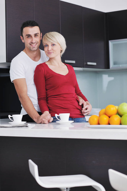 happy young couple have fun in  modern kitchen indoor  while preparing fresh fruits and vegetables food salad - Photo, image