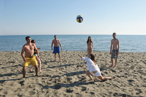 young people group have fun and play beach volleyball at sunny summer day - Photo, image