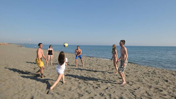 young people group have fun and play beach volleyball at sunny summer day - 写真・画像