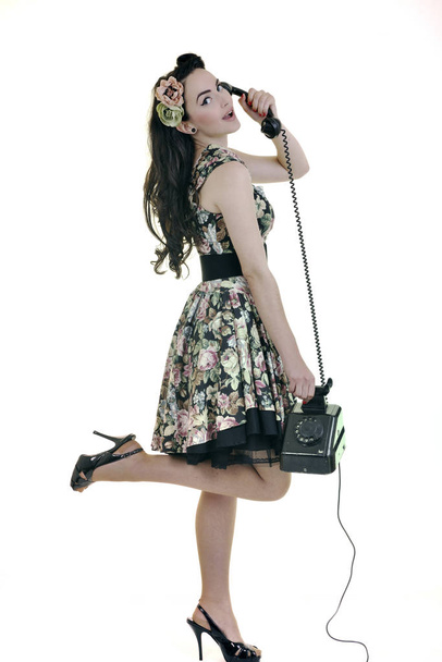 Menina bonita jovem falando no telefone velho isolado no branco no estúdio
 - Foto, Imagem