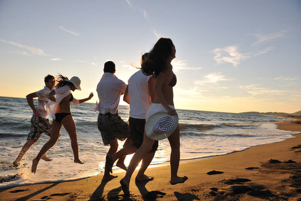 happy young people group have fun white running and jumping on beacz at sunset time - Fotoğraf, Görsel