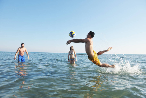 young people group have fun and play beach volleyball at sunny summer day - Foto, imagen