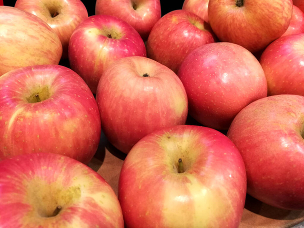 Zbliżenie i kupa czerwonych jabłek na sprzedaż na rynku. - Zdjęcie, obraz