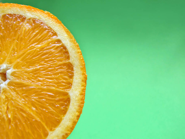 sliced orange macro on green background - Zdjęcie, obraz