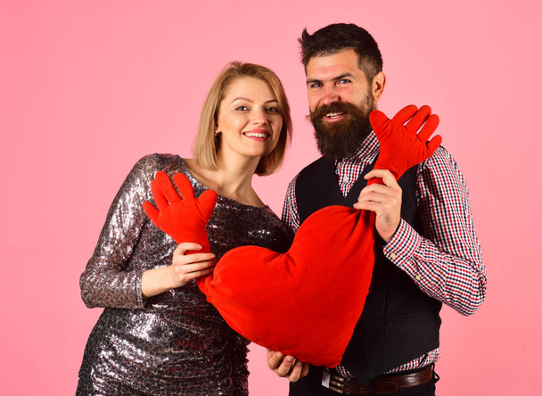 Couple in love holds big heart on pink background. - Фото, изображение