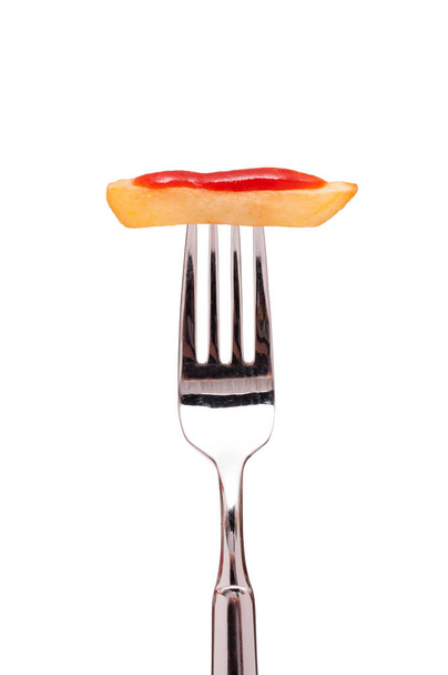 fehér, kártalanított sült krumpli piros ketchuppal egy villán - Fotó, kép