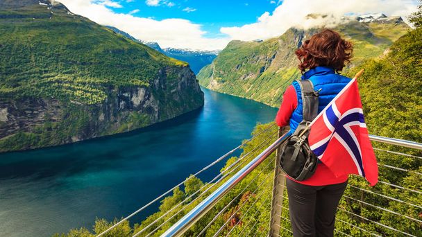 Tourist over Geirangerfjord with norwegian flag - Фото, изображение
