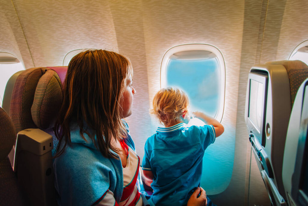 мать и маленький сын путешествуют на самолете, семья в полете
 - Фото, изображение