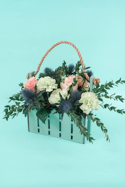 Ramo brillante en una cesta de diseño en color menta. Flores con estilo para la decoración de eventos
. - Foto, Imagen