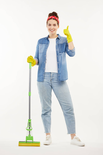 Pretty woman in work-wear holds a green mop. - Fotoğraf, Görsel