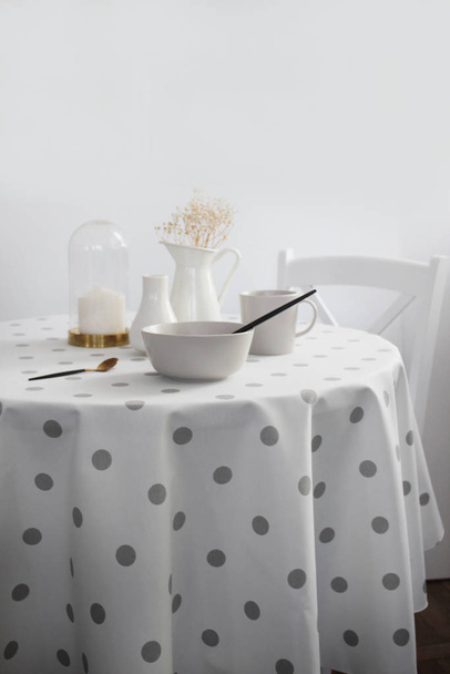 table with beautiful plates on a light background, a round table with a light tablecloth - Foto, Imagem