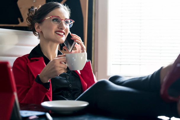 İş kadını telefonla kahve içiyor. - Fotoğraf, Görsel