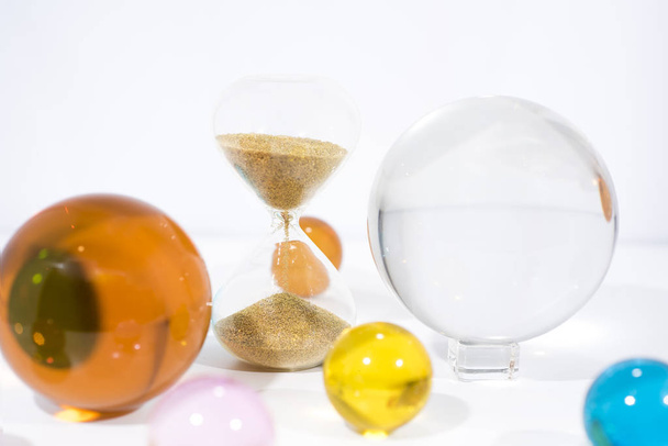 Time abstraction. Glass balls with sand clock reflections. - Photo, Image